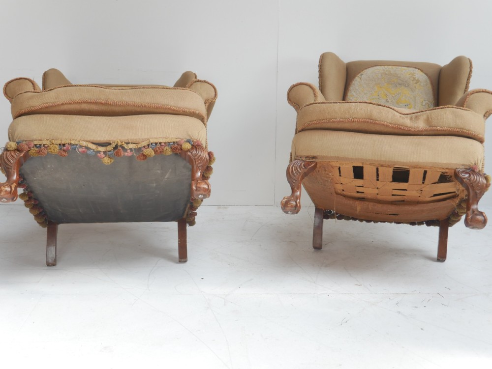 A pair of 1920s wingback armchairs upholstered in gold fabric featuring oval embroidered back panels and carved walnut ball and claw feet. View IV