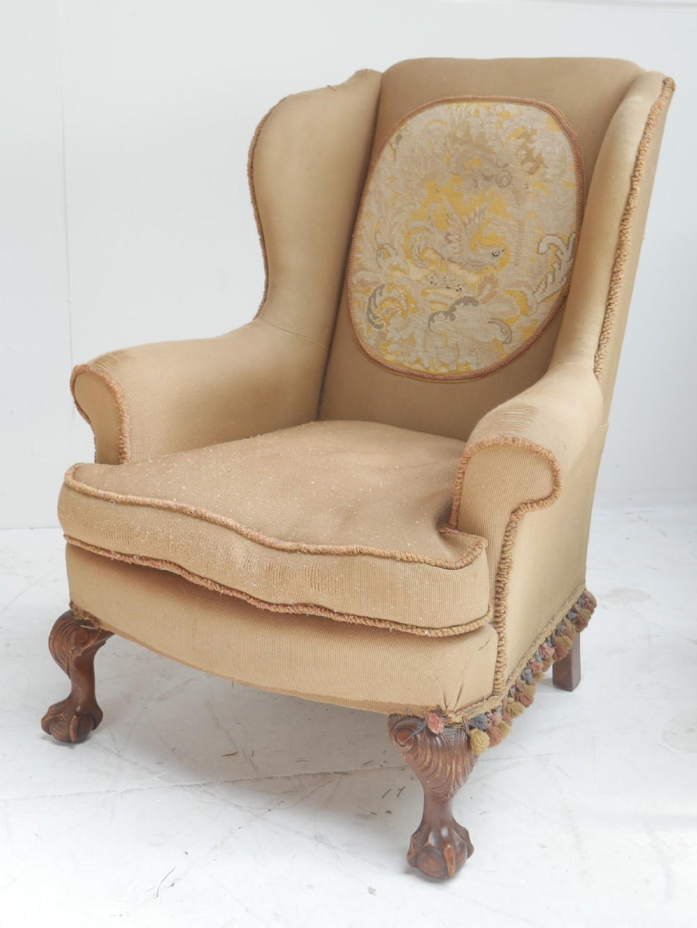 A pair of 1920s wingback armchairs upholstered in gold fabric featuring oval embroidered back panels and carved walnut ball and claw feet. View VIII