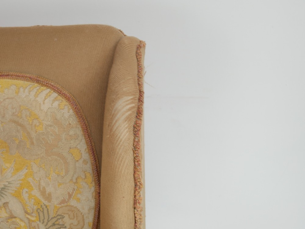 A pair of 1920s wingback armchairs upholstered in gold fabric featuring oval embroidered back panels and carved walnut ball and claw feet. View XI