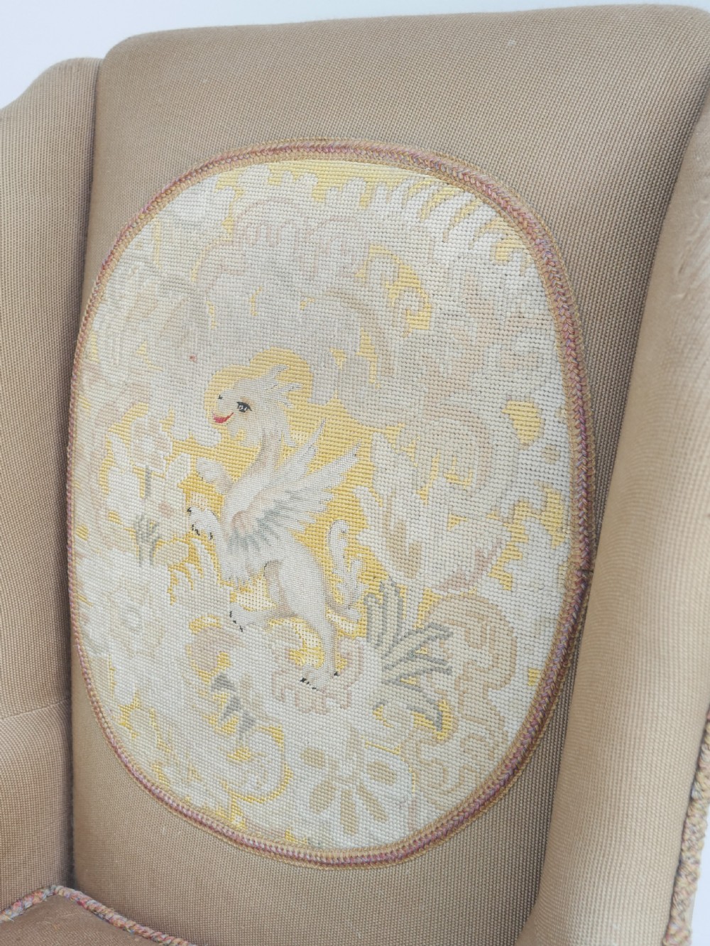A pair of 1920s wingback armchairs upholstered in gold fabric featuring oval embroidered back panels and carved walnut ball and claw feet. View XII