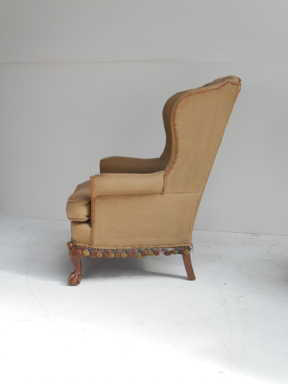 A pair of 1920s wingback armchairs upholstered in gold fabric featuring oval embroidered back panels and carved walnut ball and claw feet. View XIII