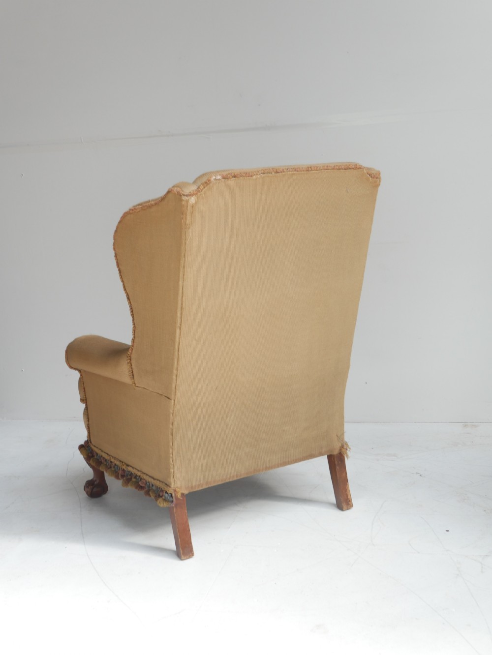 A pair of 1920s wingback armchairs upholstered in gold fabric featuring oval embroidered back panels and carved walnut ball and claw feet. View XIV