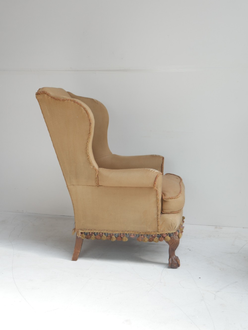 A pair of 1920s wingback armchairs upholstered in gold fabric featuring oval embroidered back panels and carved walnut ball and claw feet. View XV