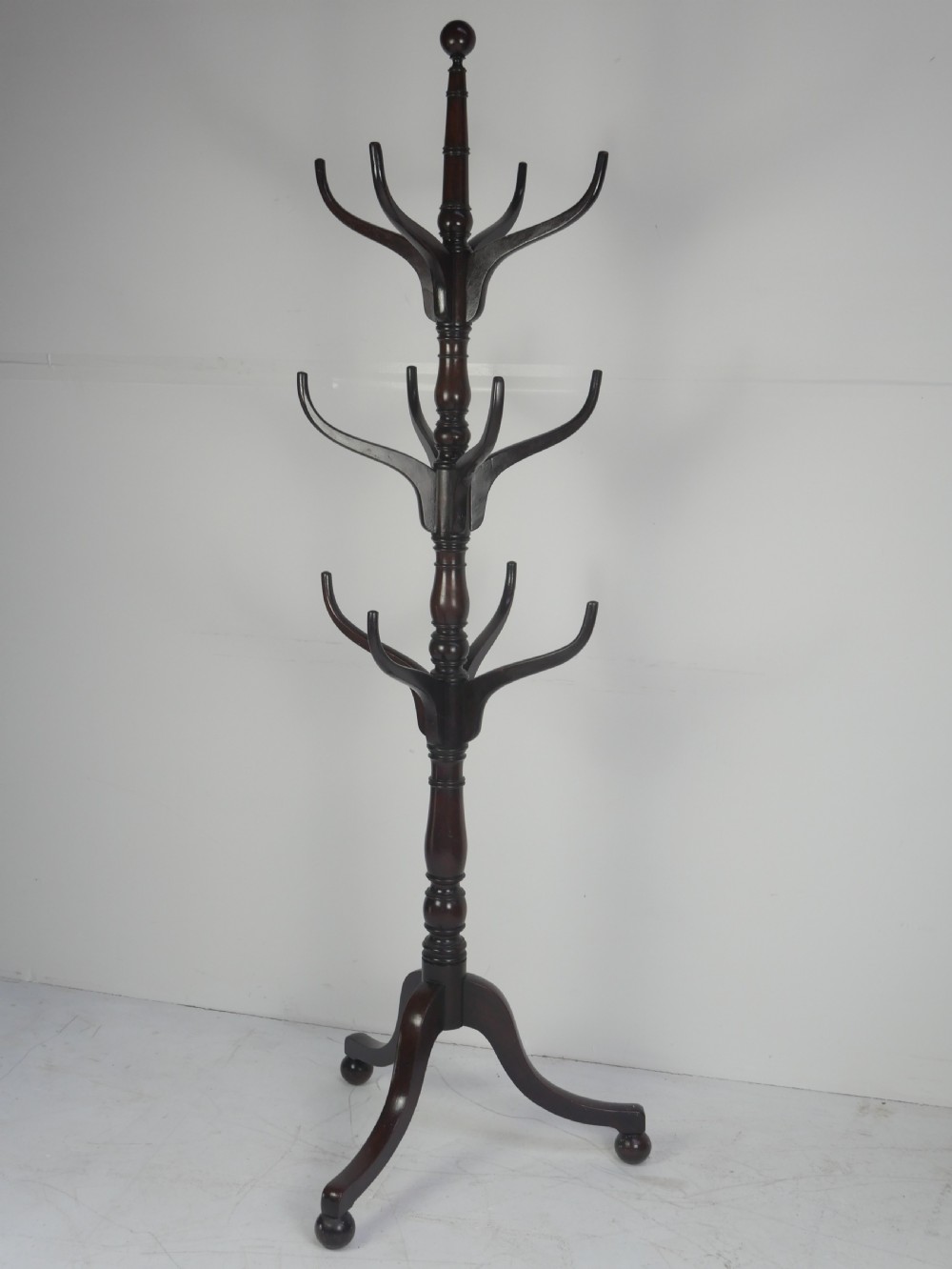 A tall 19th-century turned dark mahogany hat and coat stand with tiered curved branches and a tripod base. View IX