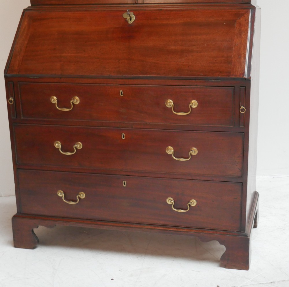 A Georgian mahogany bureau bookcase featuring a two-door glazed upper cabinet, a slant-front writing bureau, and three long drawers with brass handles. View II