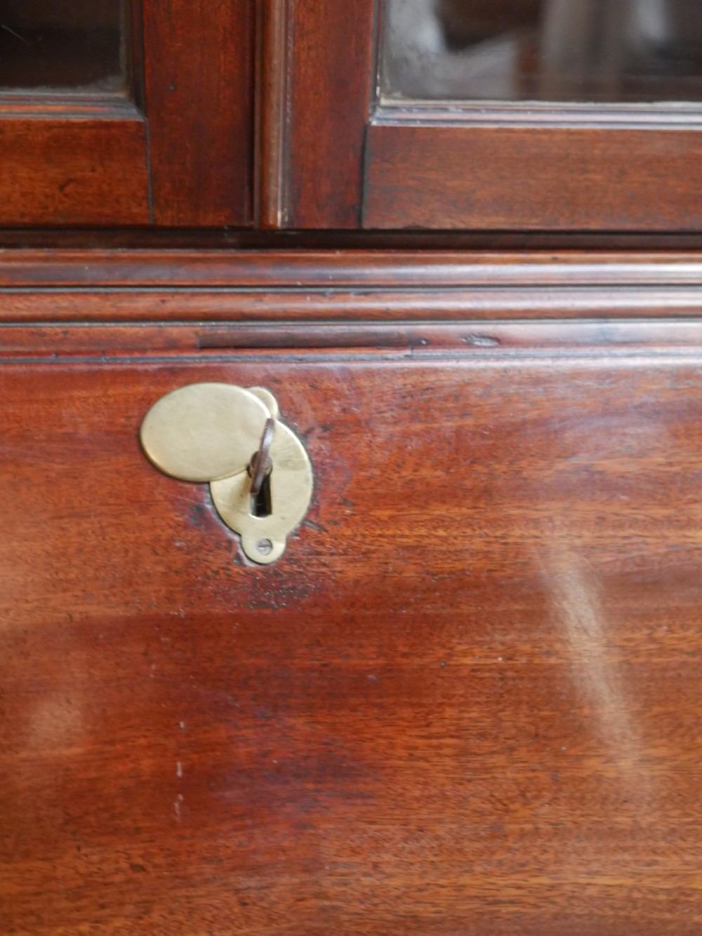 A Georgian mahogany bureau bookcase featuring a two-door glazed upper cabinet, a slant-front writing bureau, and three long drawers with brass handles. View VIII