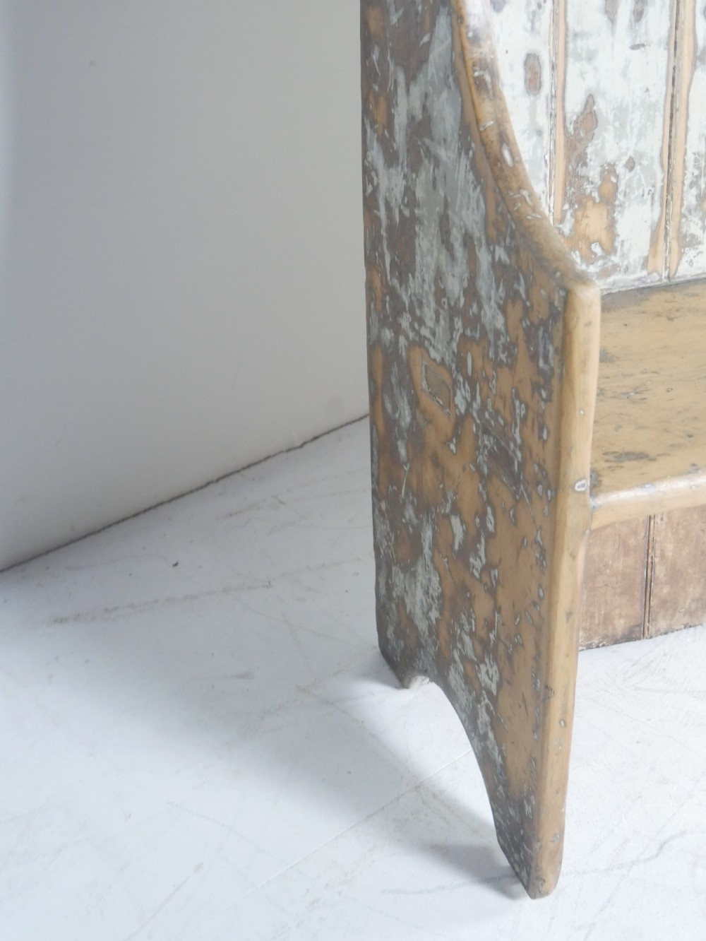 A large high-backed wooden settle bench featuring distressed cream paint over natural wood and vertical panelled detailing. View II