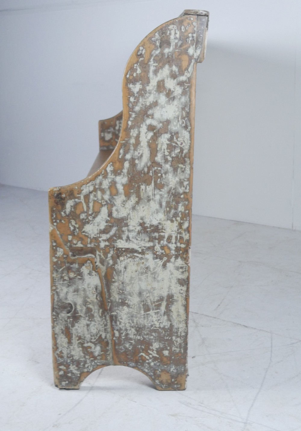 A large high-backed wooden settle bench featuring distressed cream paint over natural wood and vertical panelled detailing. View IV