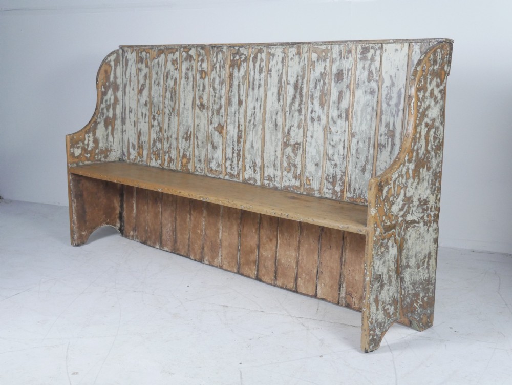 A large high-backed wooden settle bench featuring distressed cream paint over natural wood and vertical panelled detailing. View XI