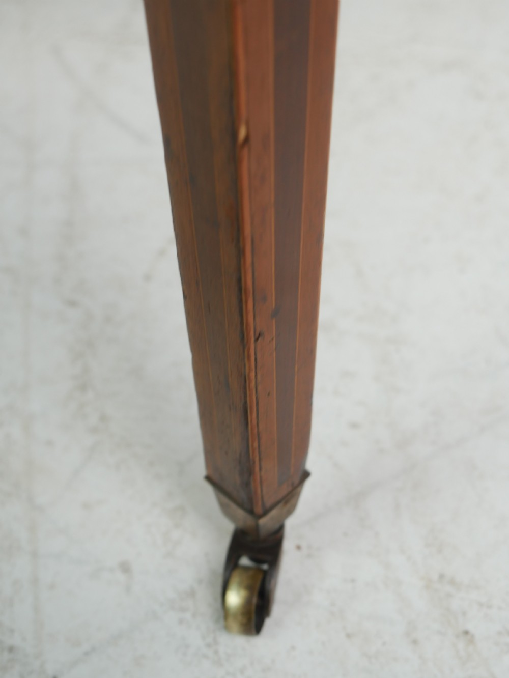 A Georgian mahogany Pembroke table featuring two drop leaves, a single drawer with a brass handle, string inlay on square tapered legs, and brass castors. View VI