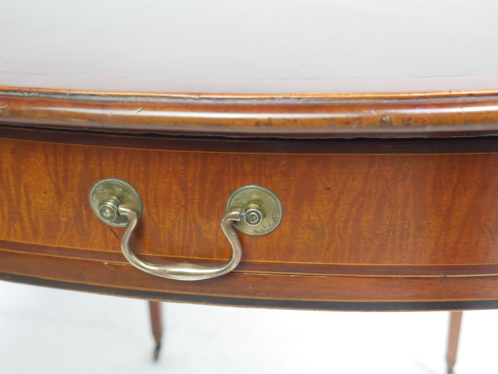 A Georgian mahogany Pembroke table featuring two drop leaves, a single drawer with a brass handle, string inlay on square tapered legs, and brass castors. View XI
