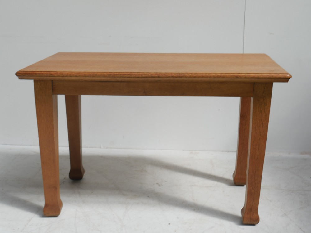 A rectangular solid oak table from the 1920s featuring tapered legs with flared feet and a moulded top edge. View V