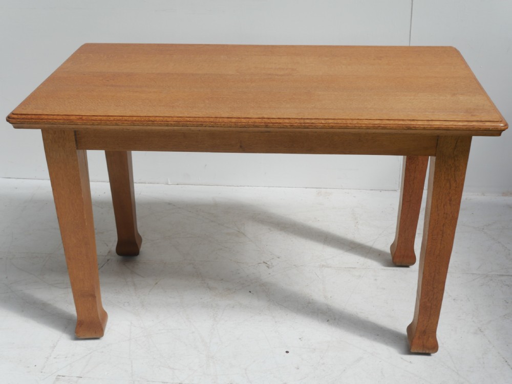 A rectangular solid oak table from the 1920s featuring tapered legs with flared feet and a moulded top edge. View VI
