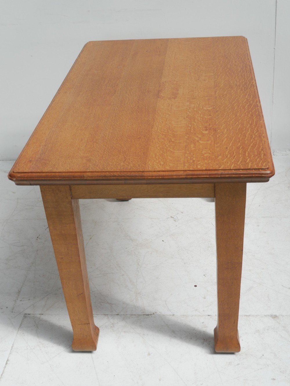 A rectangular solid oak table from the 1920s featuring tapered legs with flared feet and a moulded top edge. View VII