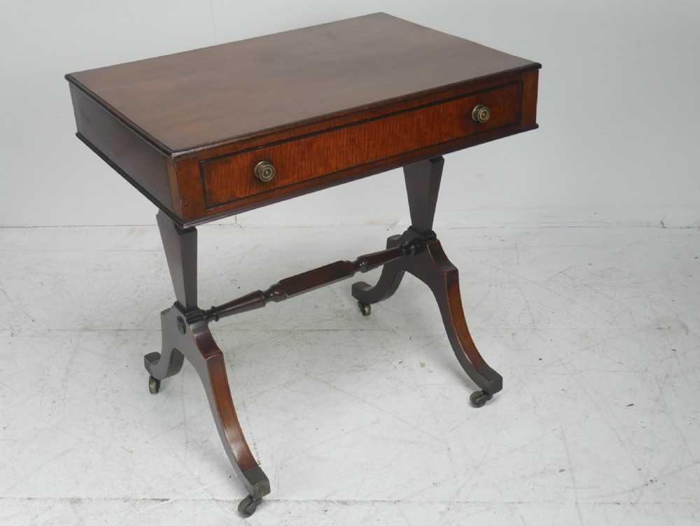 A Regency mahogany side table featuring a single drawer with brass knobs, a turned cross stretcher, and splayed legs on castors. View VIII