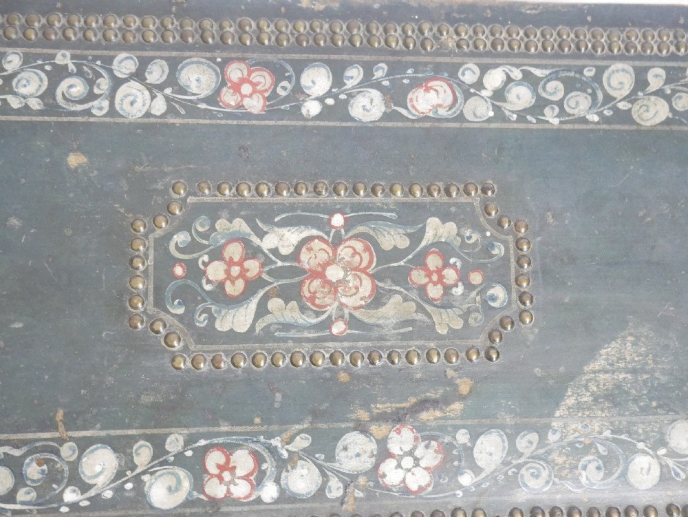 A dark green rectangular leather trunk decorated with hand-painted floral borders and studded brass tacks around the edges. View VI