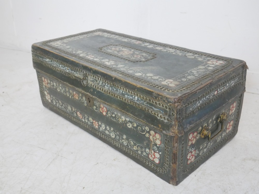 A dark green rectangular leather trunk decorated with hand-painted floral borders and studded brass tacks around the edges. View XV