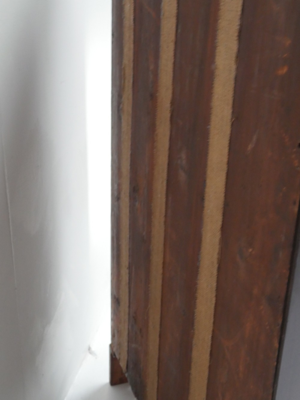 A tall, narrow mahogany chest of drawers featuring seven graduated drawers with brass drop handles and decorative shaped bracket feet. View VII