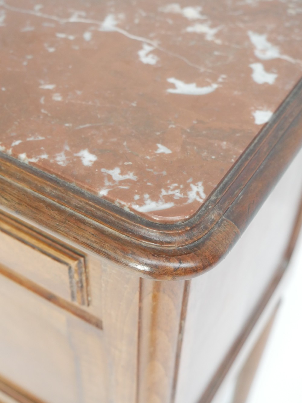 A French provincial walnut bedside cabinet with a red marble top, single drawer, inlaid wooden door, and slender turned legs. View II