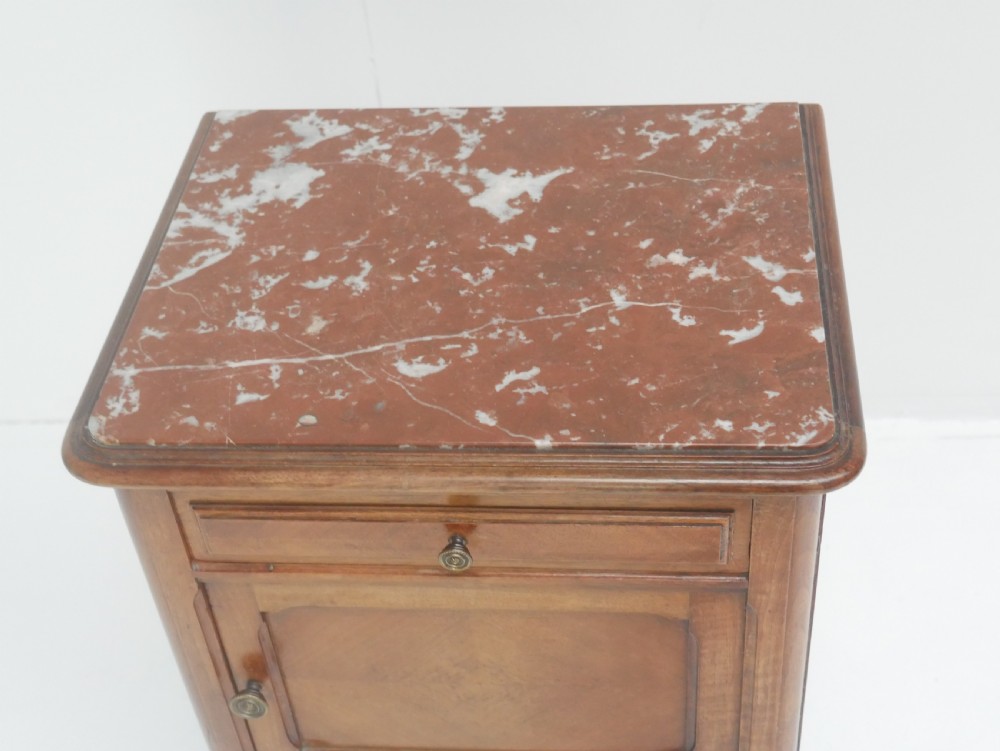 A French provincial walnut bedside cabinet with a red marble top, single drawer, inlaid wooden door, and slender turned legs. View III