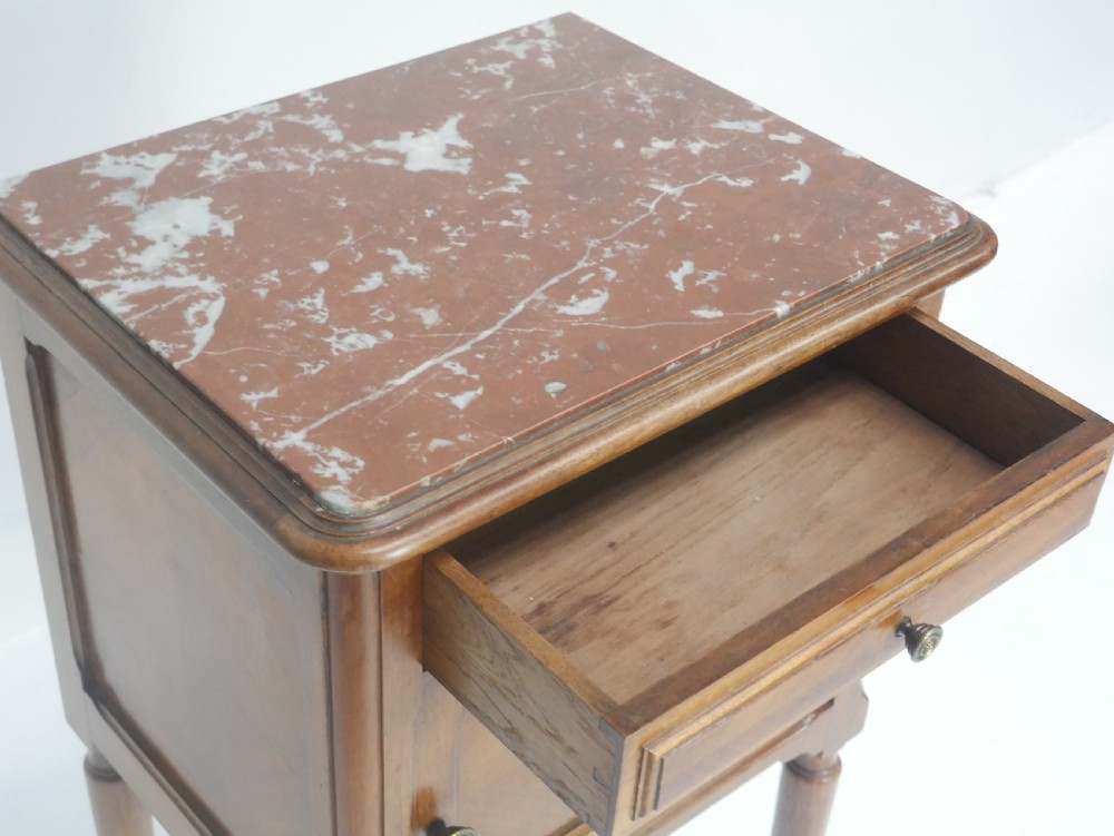 A French provincial walnut bedside cabinet with a red marble top, single drawer, inlaid wooden door, and slender turned legs. View VII