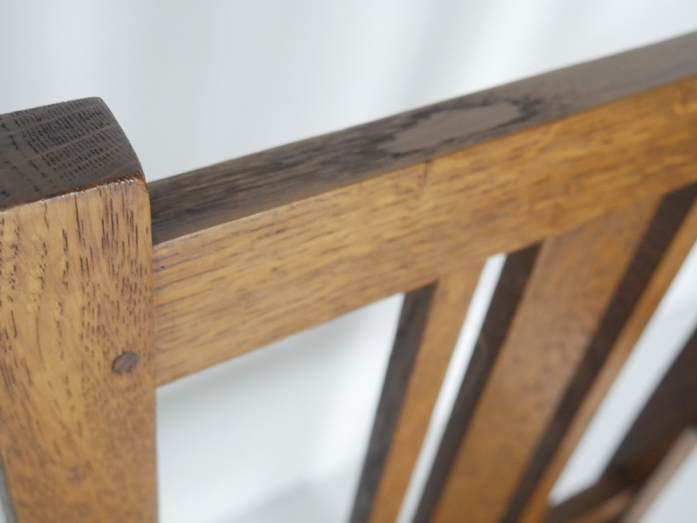 An Arts and Crafts solid oak armchair with a slatted backrest, flat armrests, and a botanical patterned fabric seat secured with studs. View VIII