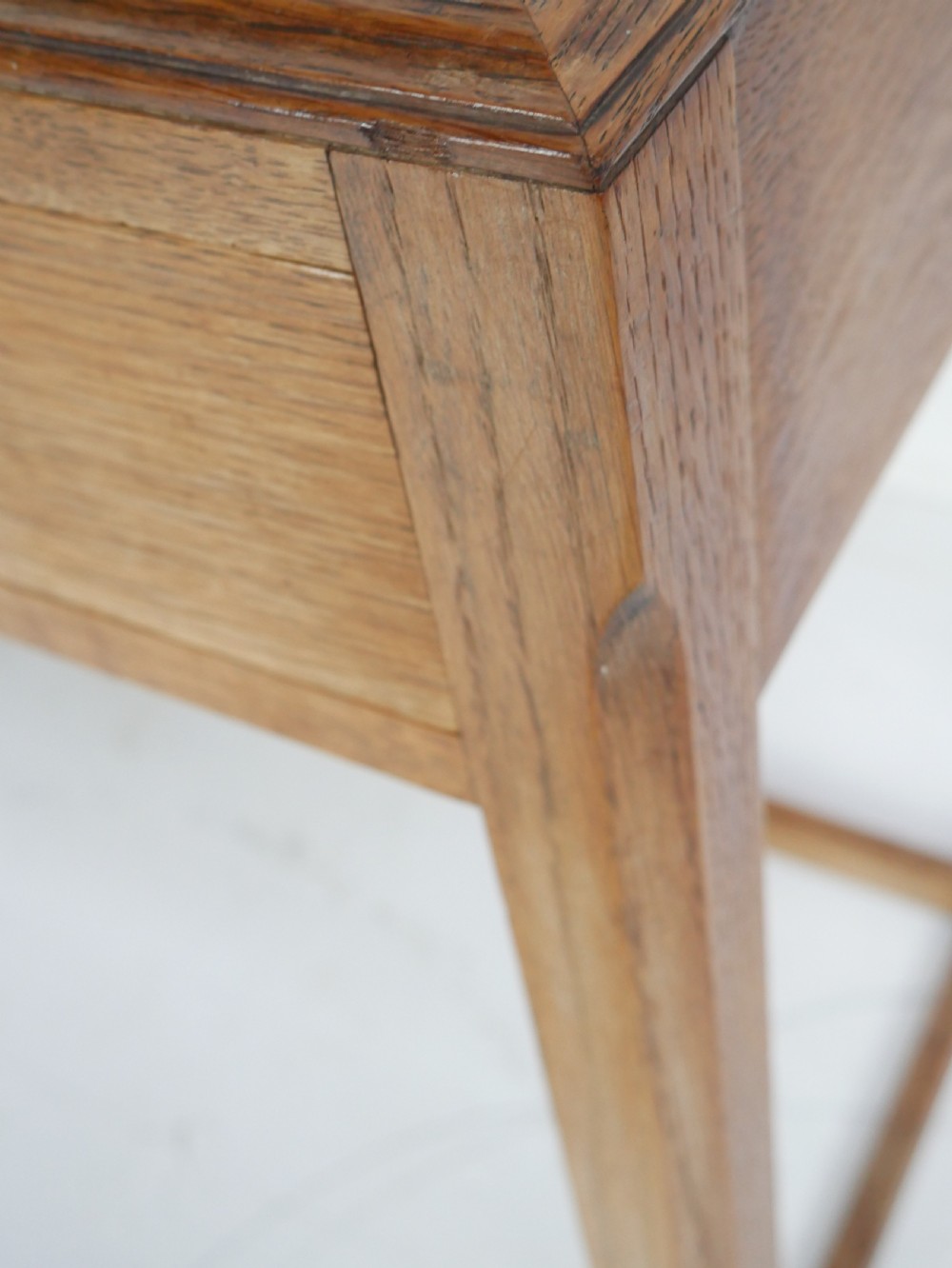 A light oak childs writing desk featuring a red inset leather top, two drawers with wooden pulls, and a square-section frame with a low floor stretcher. View XV