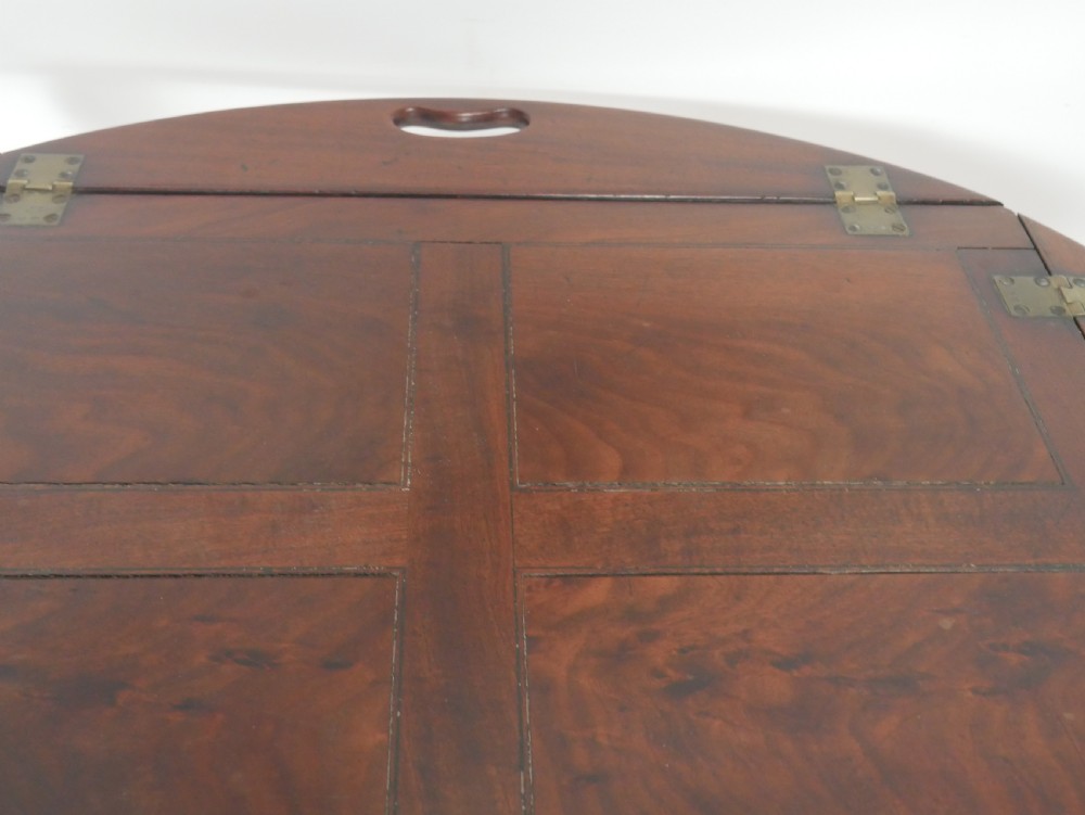 A Regency mahogany butlers tray featuring cutout handles and hinged sides resting on a turned folding X-frame stand. View V