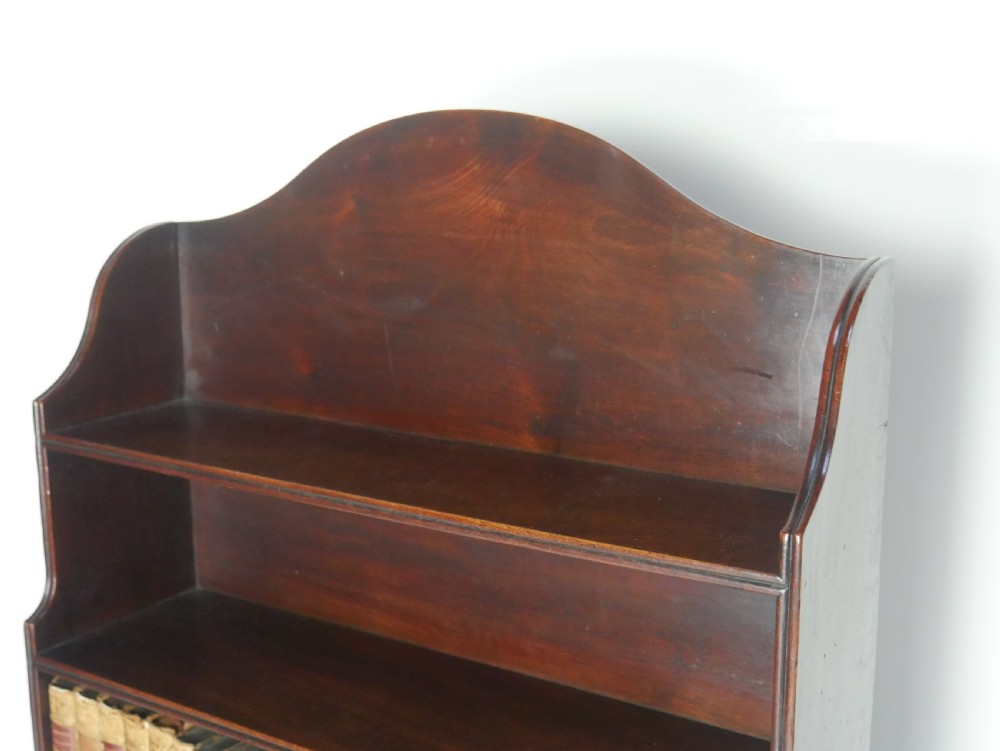 A dark mahogany Georgian waterfall bookcase featuring three open graduated shelves above a single drawer with brass handles. View III