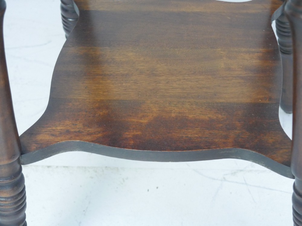 A dark brown wooden 1920s lamp table featuring four turned legs, a square top with carved edge detailing, and a lower tier shelf. View VII