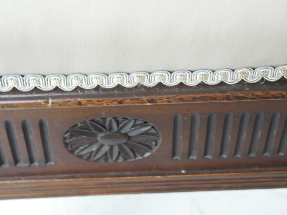 A rectangular antique mahogany piano stool featuring fluted tapered legs, carved central rosettes, and a floral needlepoint tapestry top. View X