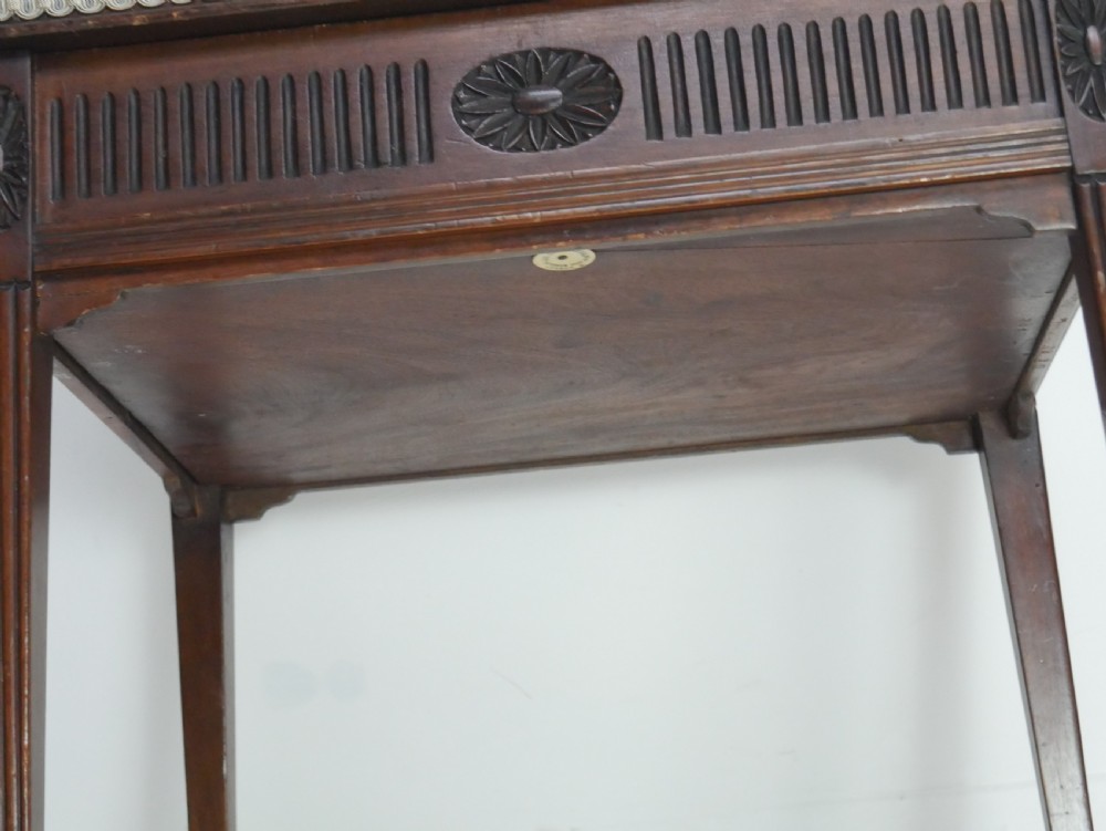 A rectangular antique mahogany piano stool featuring fluted tapered legs, carved central rosettes, and a floral needlepoint tapestry top. View XI