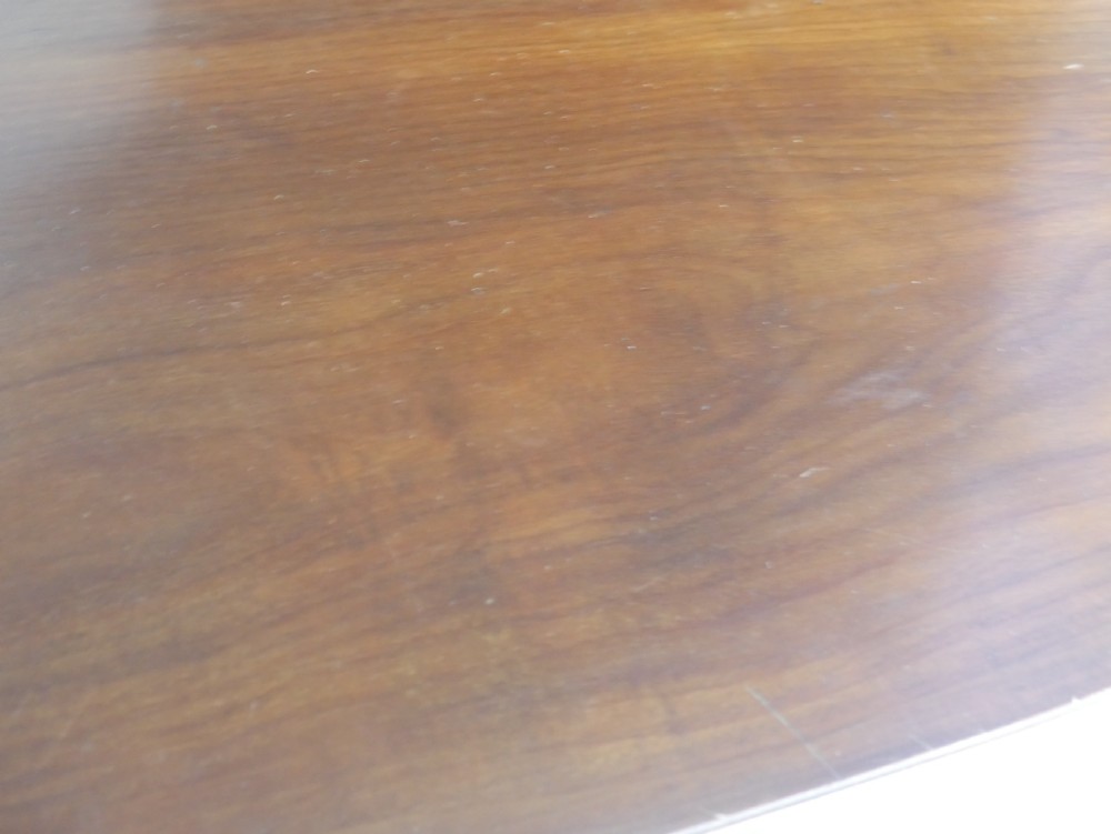 An antique mahogany drop-leaf dining table with reeded legs set on brass castors, shown fully extended. View V