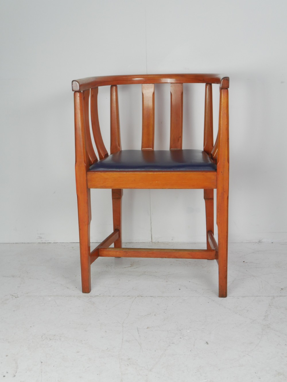A pair of warm wood Arts and Crafts tub chairs with curved slat backs and blue upholstered seats. View VI