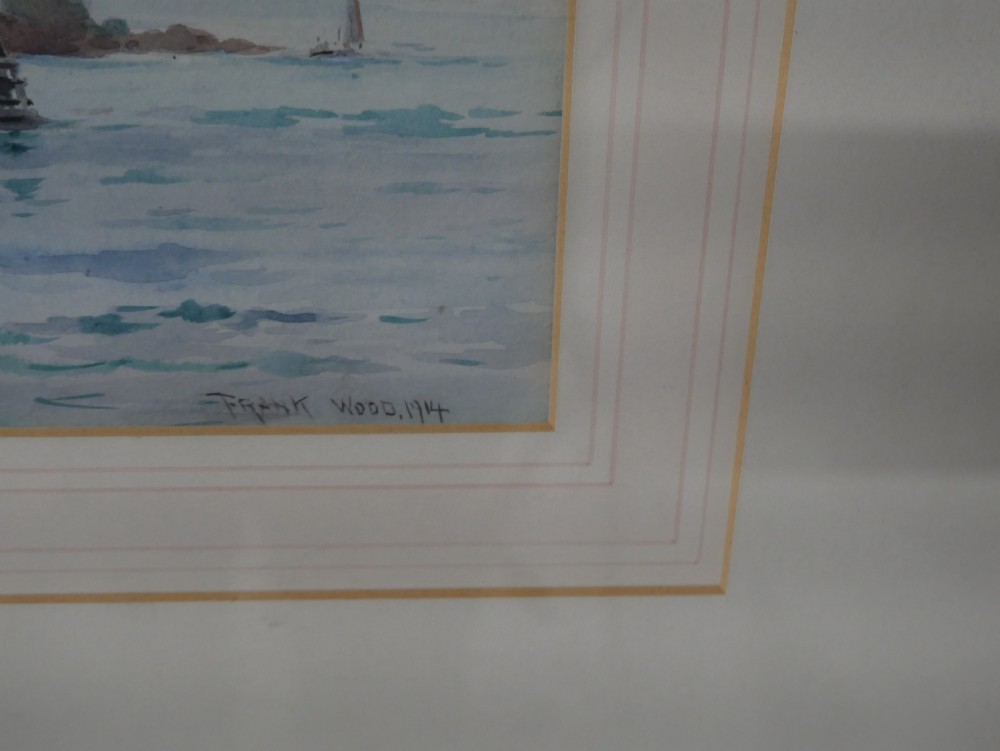 A framed Edwardian marine watercolour painting depicting a multi-masted sailing vessel at anchor near a hilly coastline in a slender gilt frame with a double mount. View III