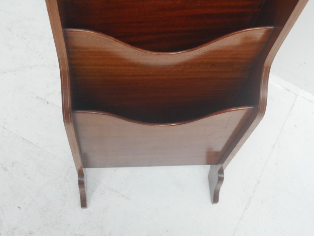 A freestanding three-tiered mahogany magazine rack featuring curved cutout fronts, an integrated top handle, and inlaid stringing borders on splayed feet. View III