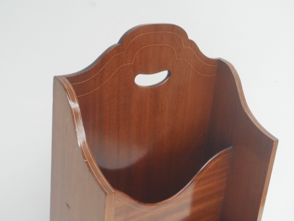 A freestanding three-tiered mahogany magazine rack featuring curved cutout fronts, an integrated top handle, and inlaid stringing borders on splayed feet. View V