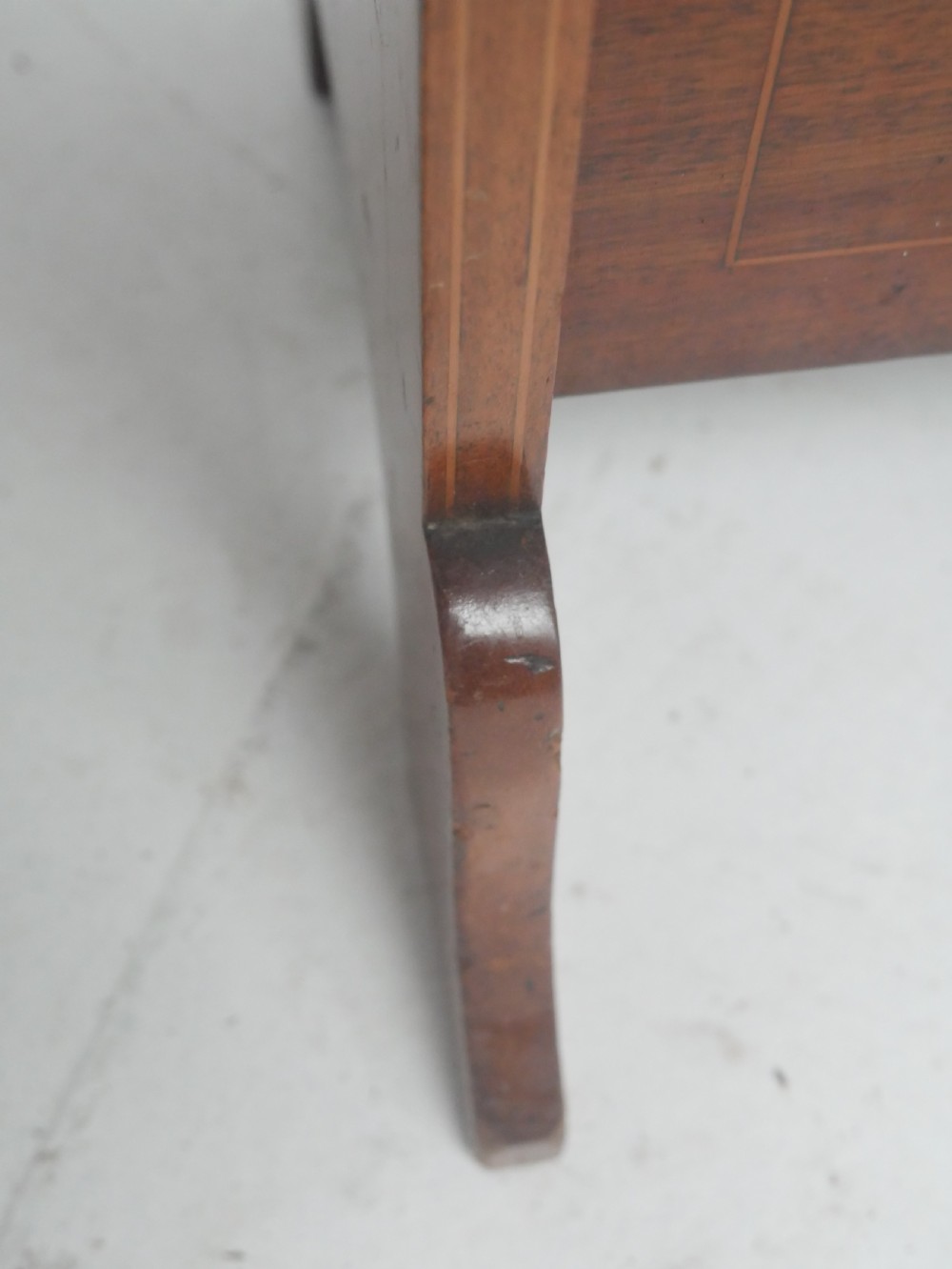 A freestanding three-tiered mahogany magazine rack featuring curved cutout fronts, an integrated top handle, and inlaid stringing borders on splayed feet. View VI