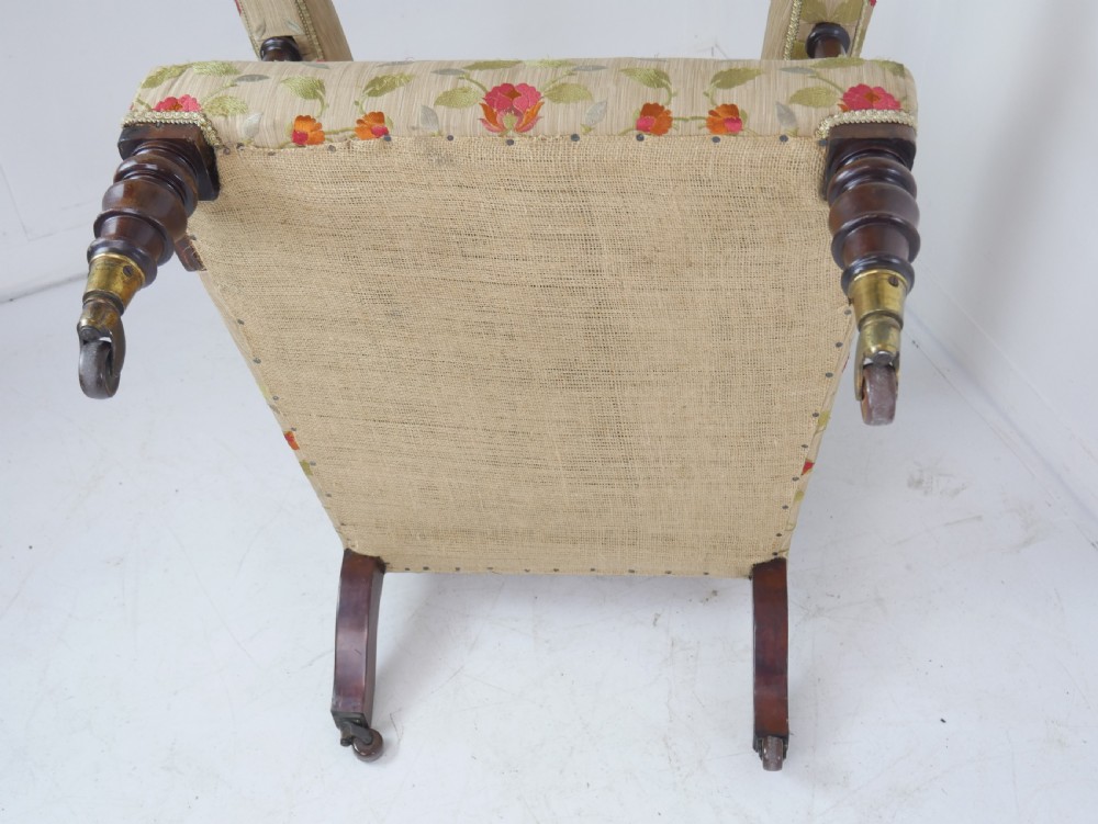 A 19th-century Victorian armchair featuring beige floral upholstery, a deep button-back rest, padded armrests, and turned mahogany legs set on brass casters. View IX