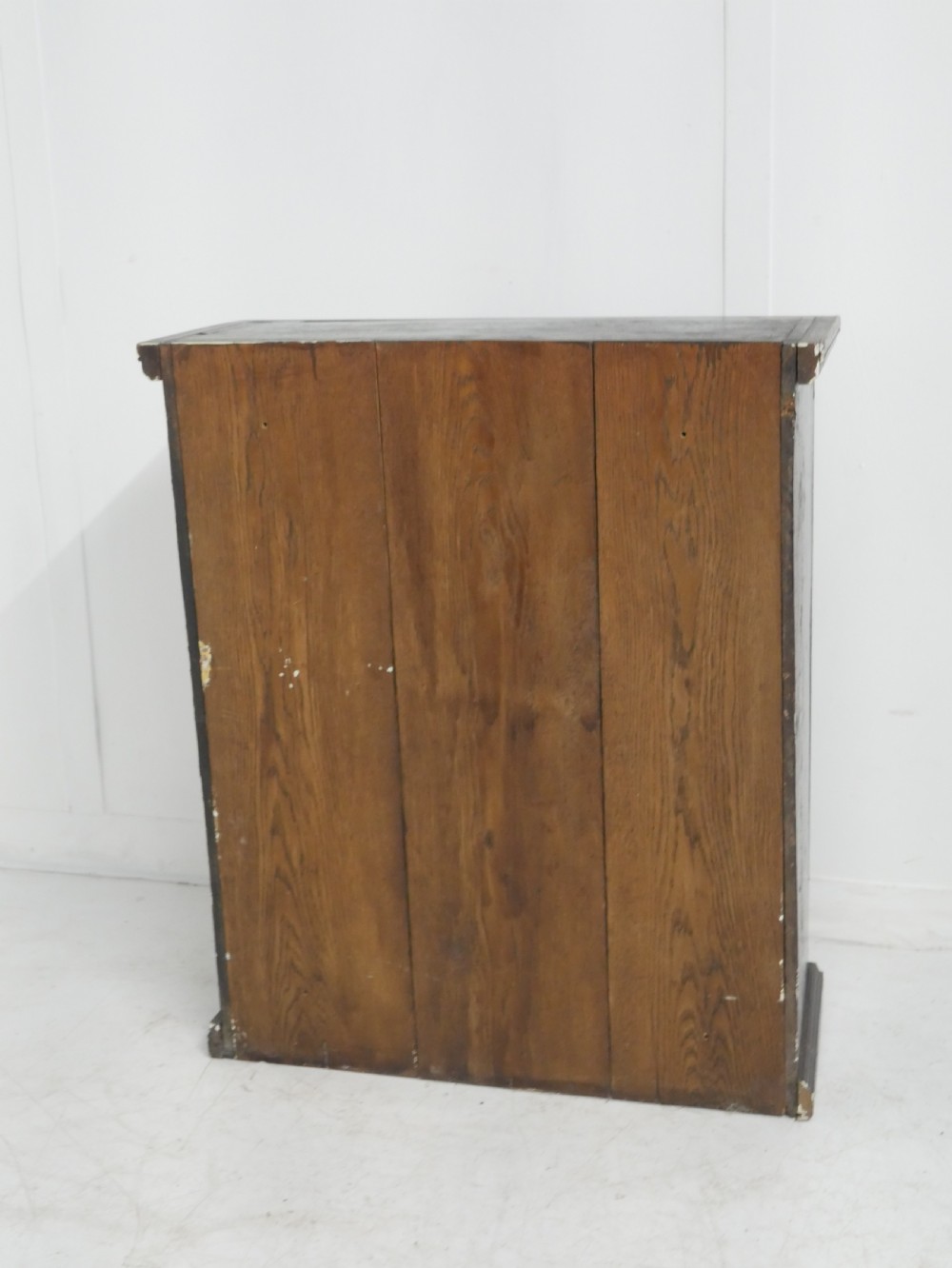 A dark brown Georgian oak wall cupboard with a single four-panel door, brass keyhole escutcheon, and moulded top cornice. View VII