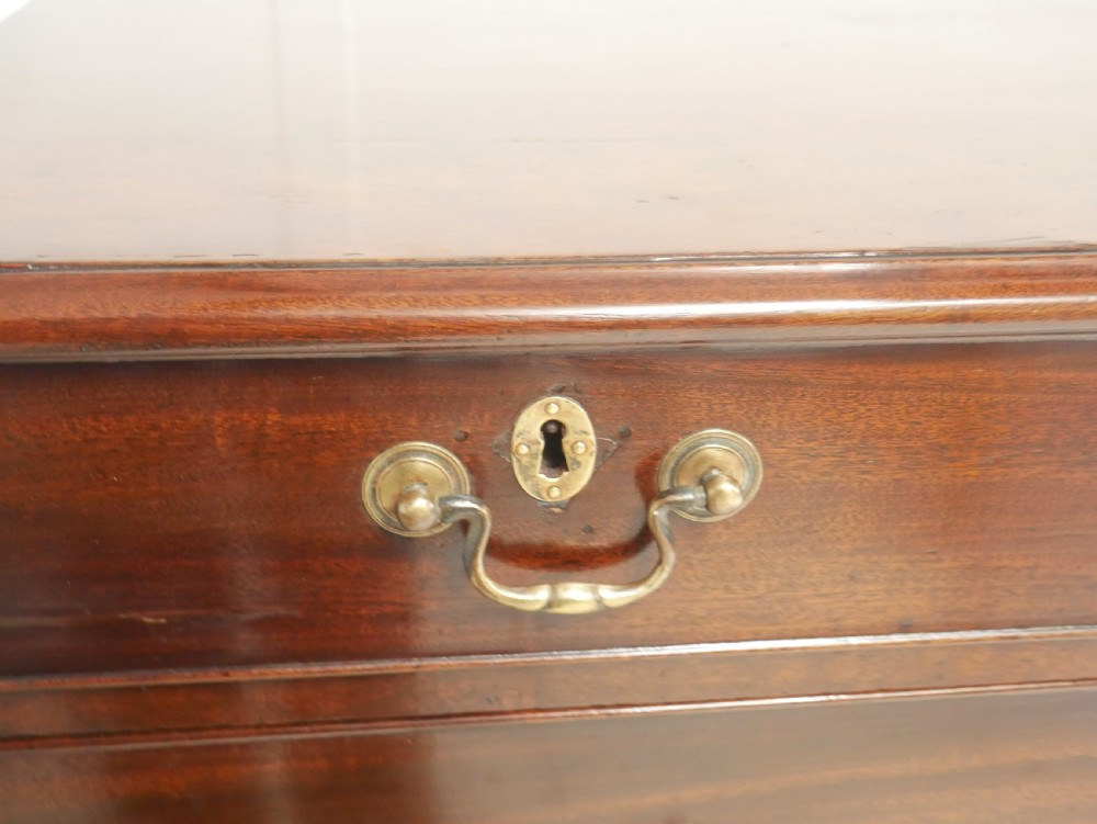 A Georgian mahogany chest of drawers featuring a two-over-three drawer layout, brass swan-neck handles, and bracket feet. View X