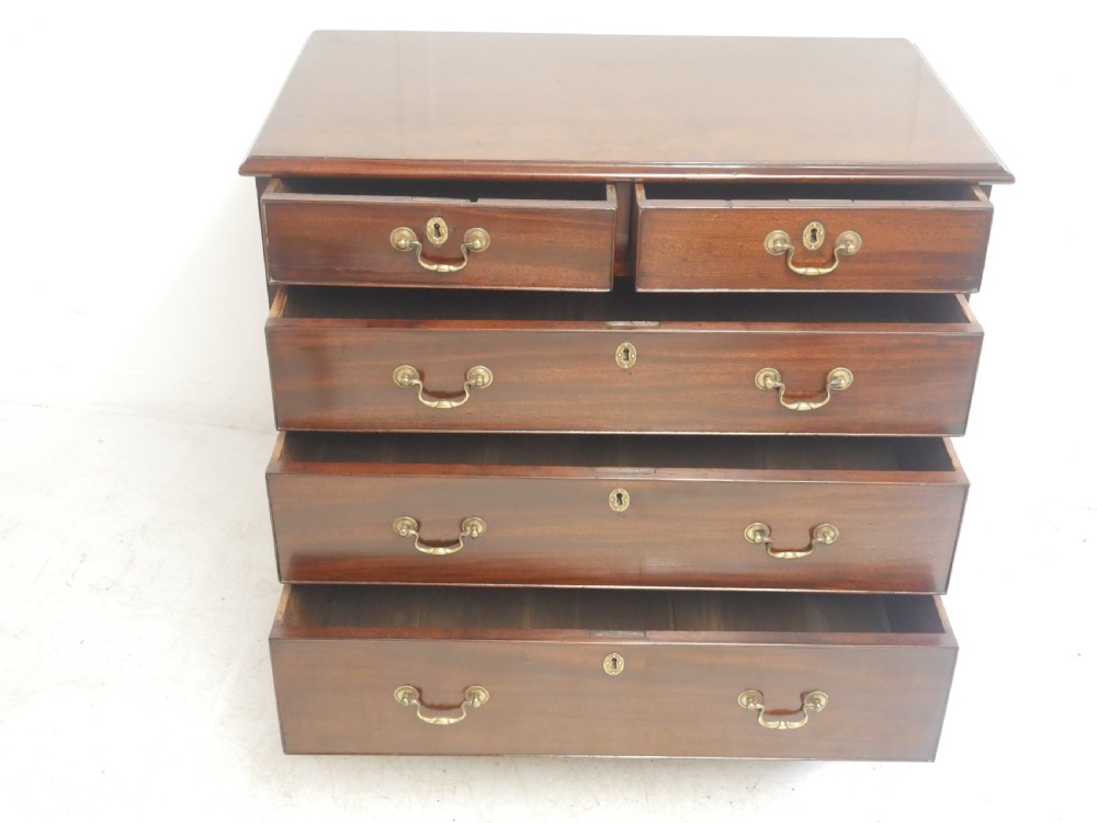 A Georgian mahogany chest of drawers featuring a two-over-three drawer layout, brass swan-neck handles, and bracket feet. View XI