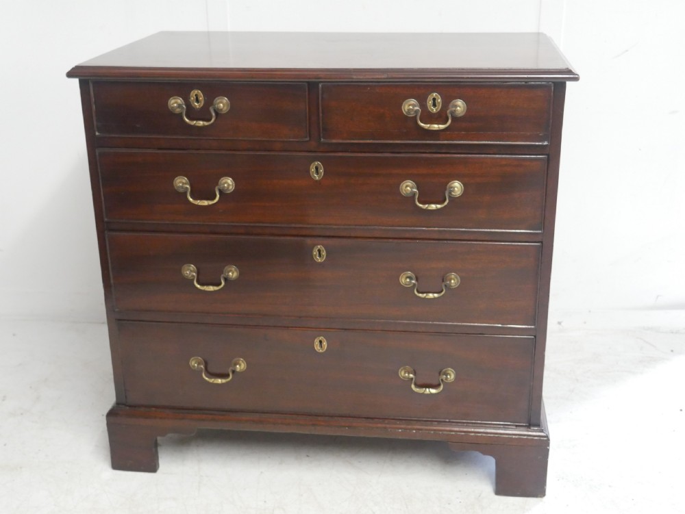 A Georgian mahogany chest of drawers featuring a two-over-three drawer layout, brass swan-neck handles, and bracket feet. View XIII