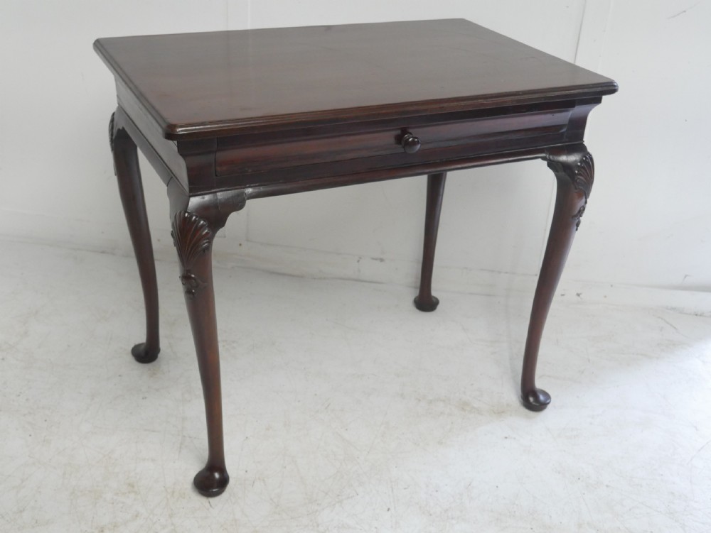 A 19th-century dark mahogany side table featuring a single frieze drawer, carved shell motifs on cabriole legs, and pad feet.