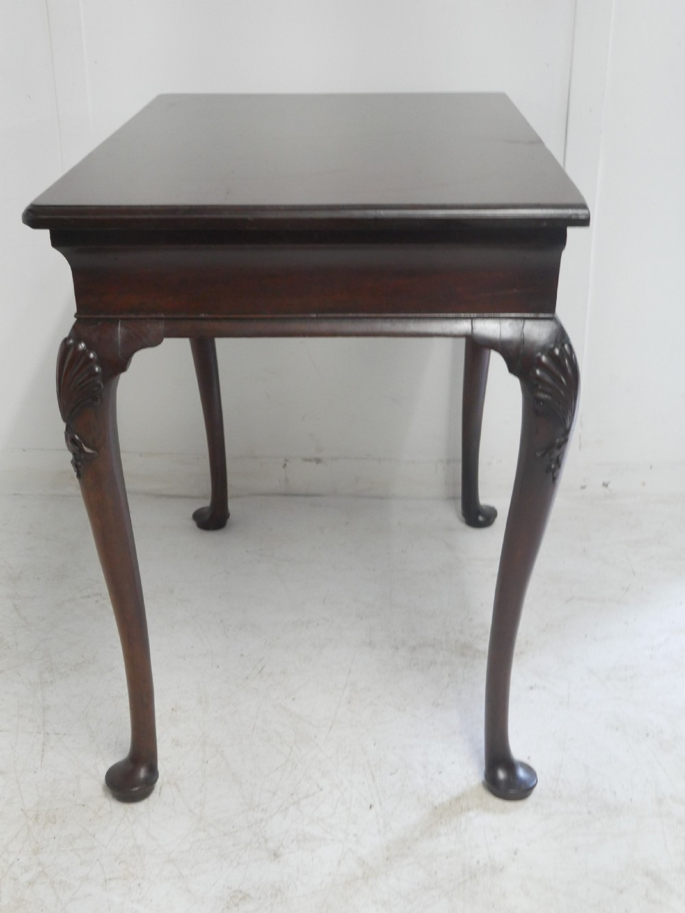 A 19th-century dark mahogany side table featuring a single frieze drawer, carved shell motifs on cabriole legs, and pad feet. View V