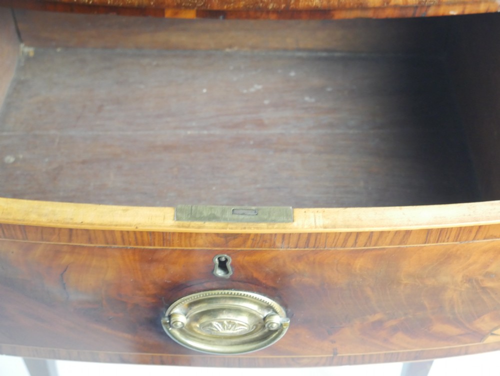 A Georgian bow-front mahogany sideboard featuring satinwood inlays, brass oval handles, and square tapered legs. View XIII