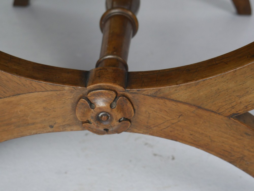 A Regency period rosewood X-frame stool with a turned stretcher bar and a square upholstered top featuring floral needlework set within a green border. View VI