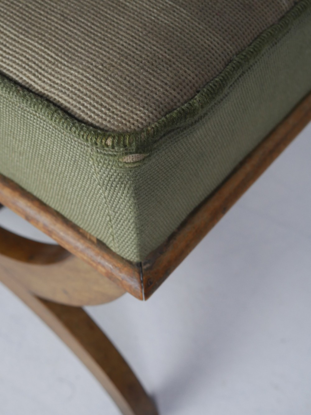 A Regency period rosewood X-frame stool with a turned stretcher bar and a square upholstered top featuring floral needlework set within a green border. View X