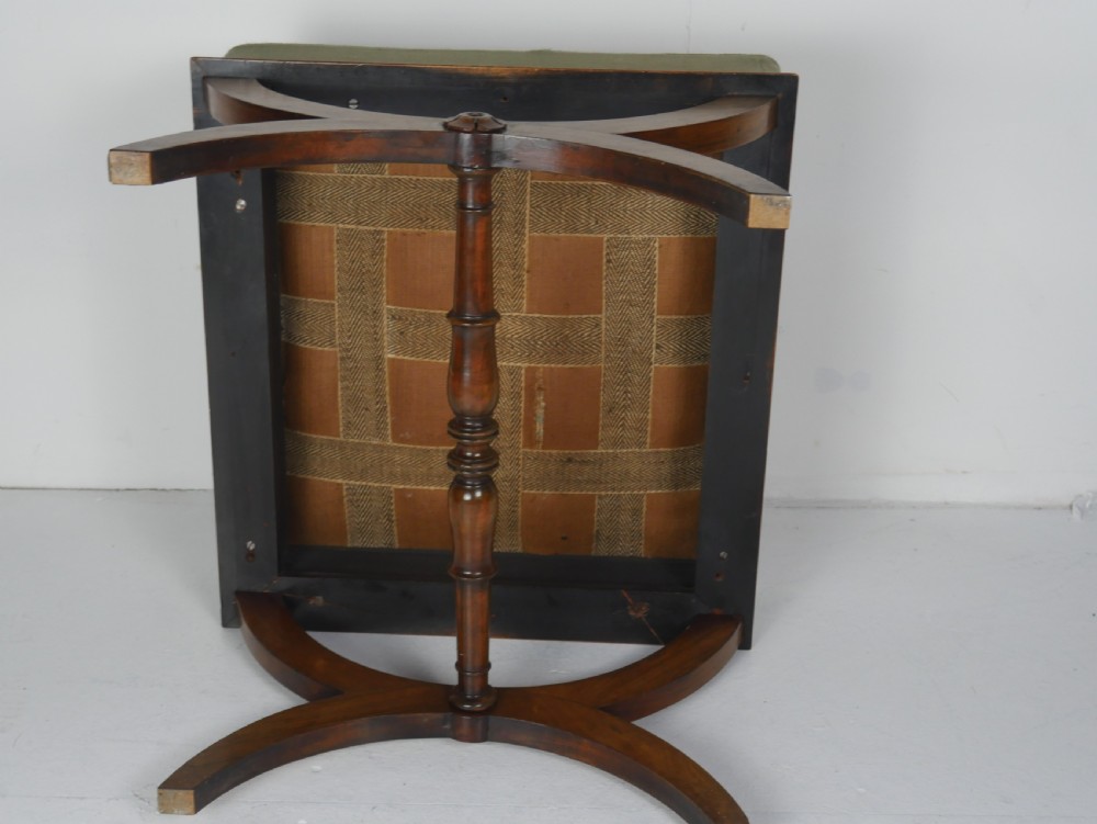 A Regency period rosewood X-frame stool with a turned stretcher bar and a square upholstered top featuring floral needlework set within a green border. View XII