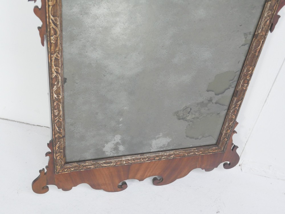 A Georgian mahogany wall mirror featuring a scroll-carved fretwork frame with an inner gilded slip border. View III